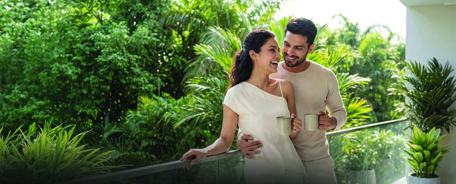 A couple on a planted balcony overlooking greenery